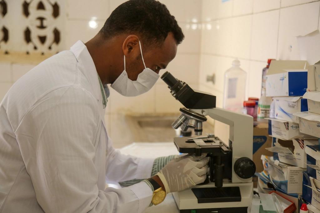A scientist at a laboratory microscope